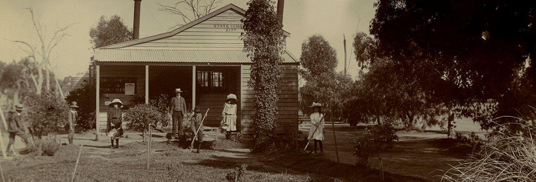 Black and white photo of people in front of farmhouse